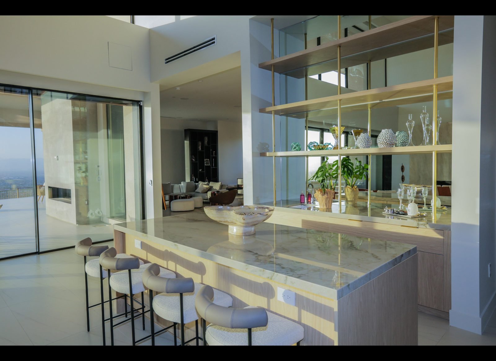 Stone bar with brass shelving and bar stools