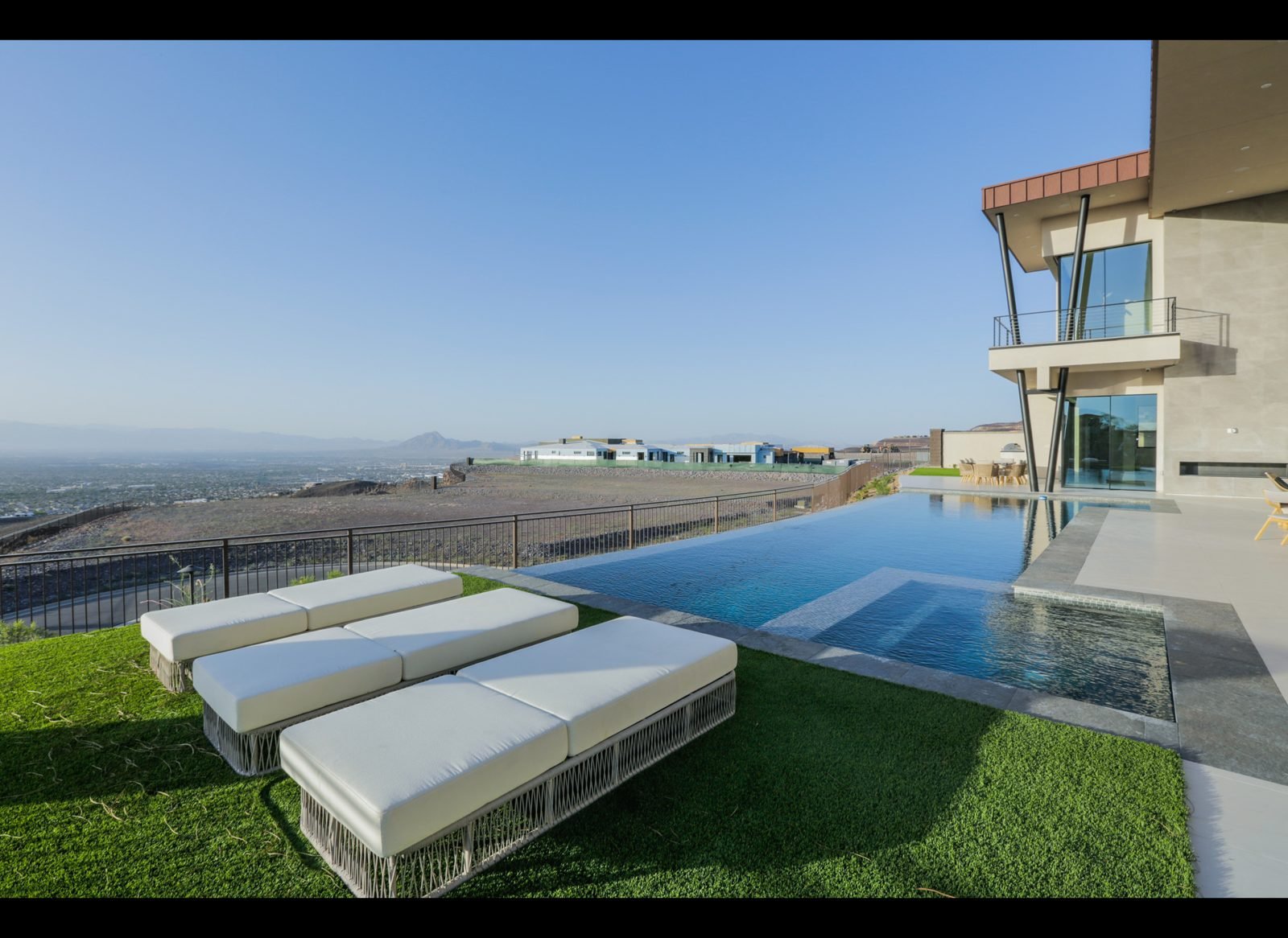 Infinity pool terrace with loungers and valley views